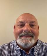 A person with a beard and mustache

Description automatically generated